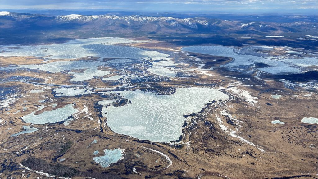 Aerial image of icy water features within a brown landscape.
